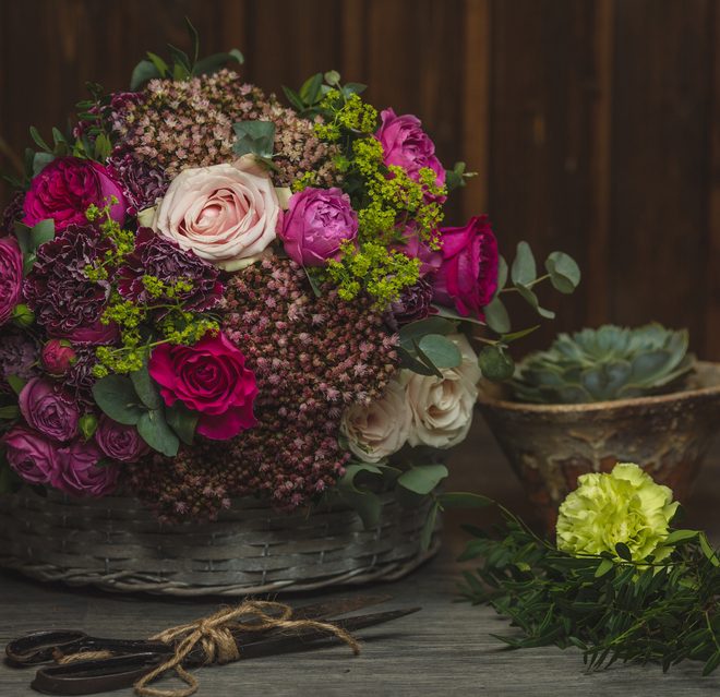 A lush mix of pink and purple blooms with red textured greens