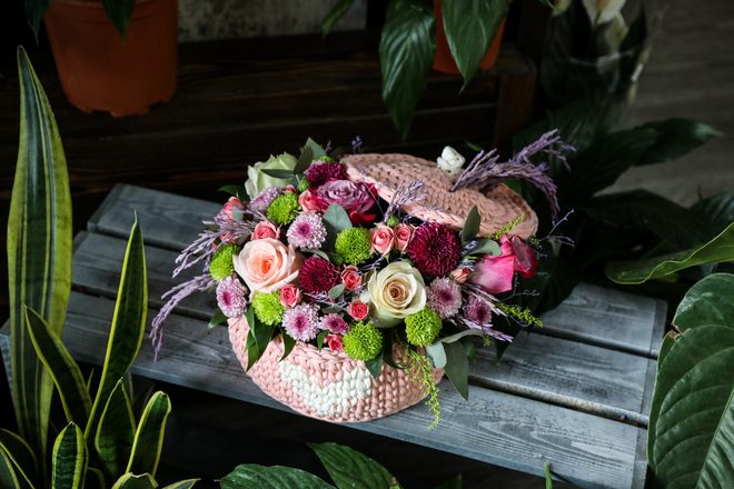 Peach and blush rose arrangement in a straw basket
