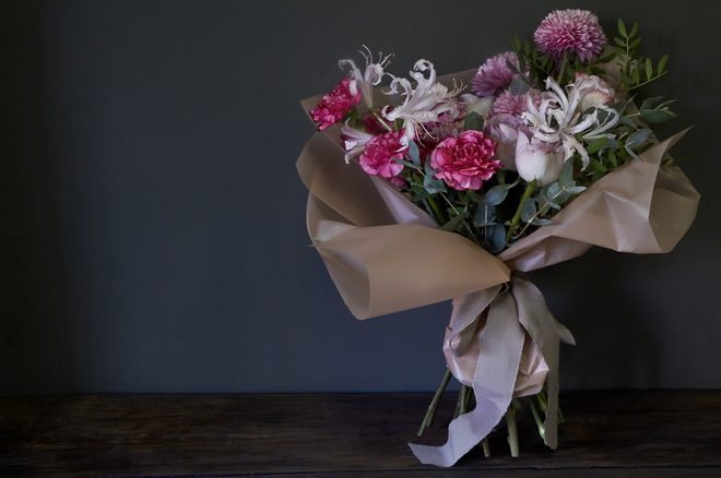 Pink carnations and roses wrapped in satin paper