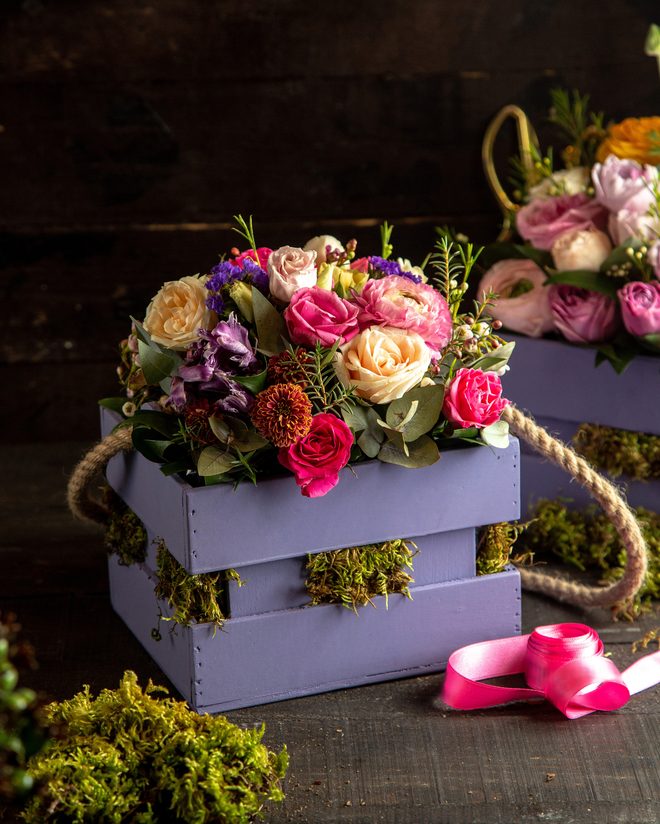 Vivid bouquet of tulips and roses in a lavender box