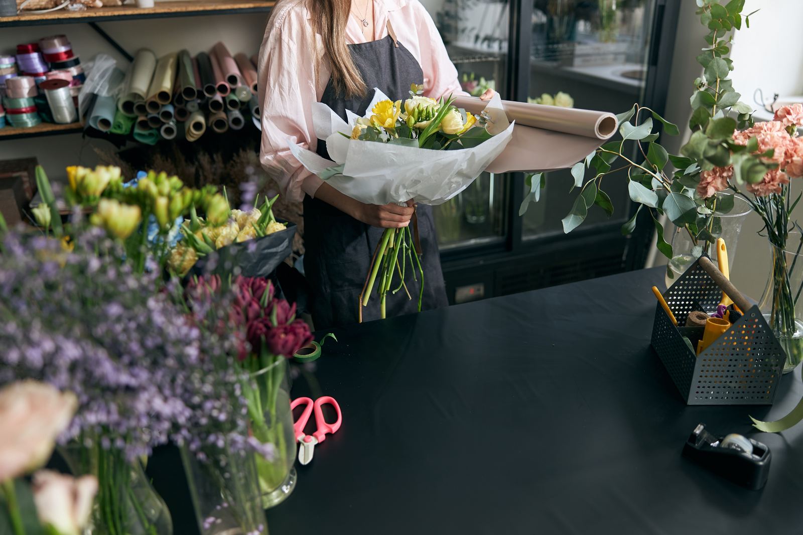 Florist preparing a yellow bouquet at the shop counter