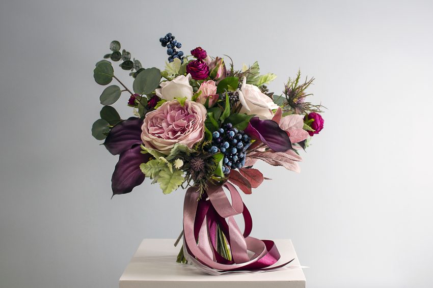 A composition of roses and seasonal greenery